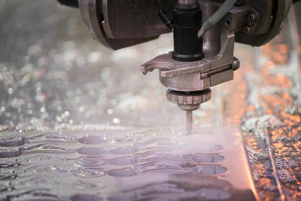 A Machine Is Cutting A Piece Of Metal With Water — Wallers Precision Tooling In Proserpine, QLD