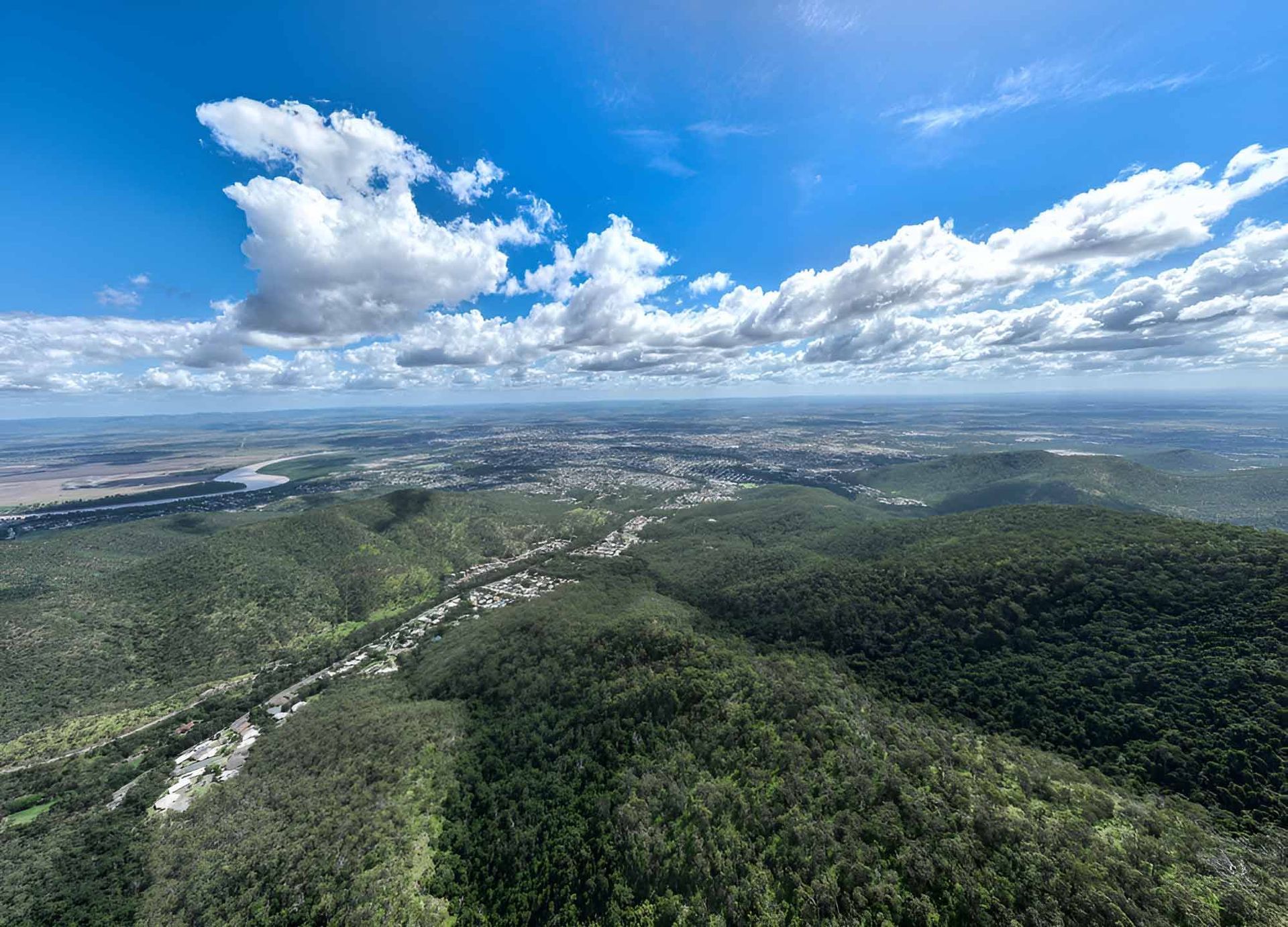 An Aerial View Of A Lush Green Forest With A City In The Distance — Wallers Precision Tooling In Rockhampton, QLD