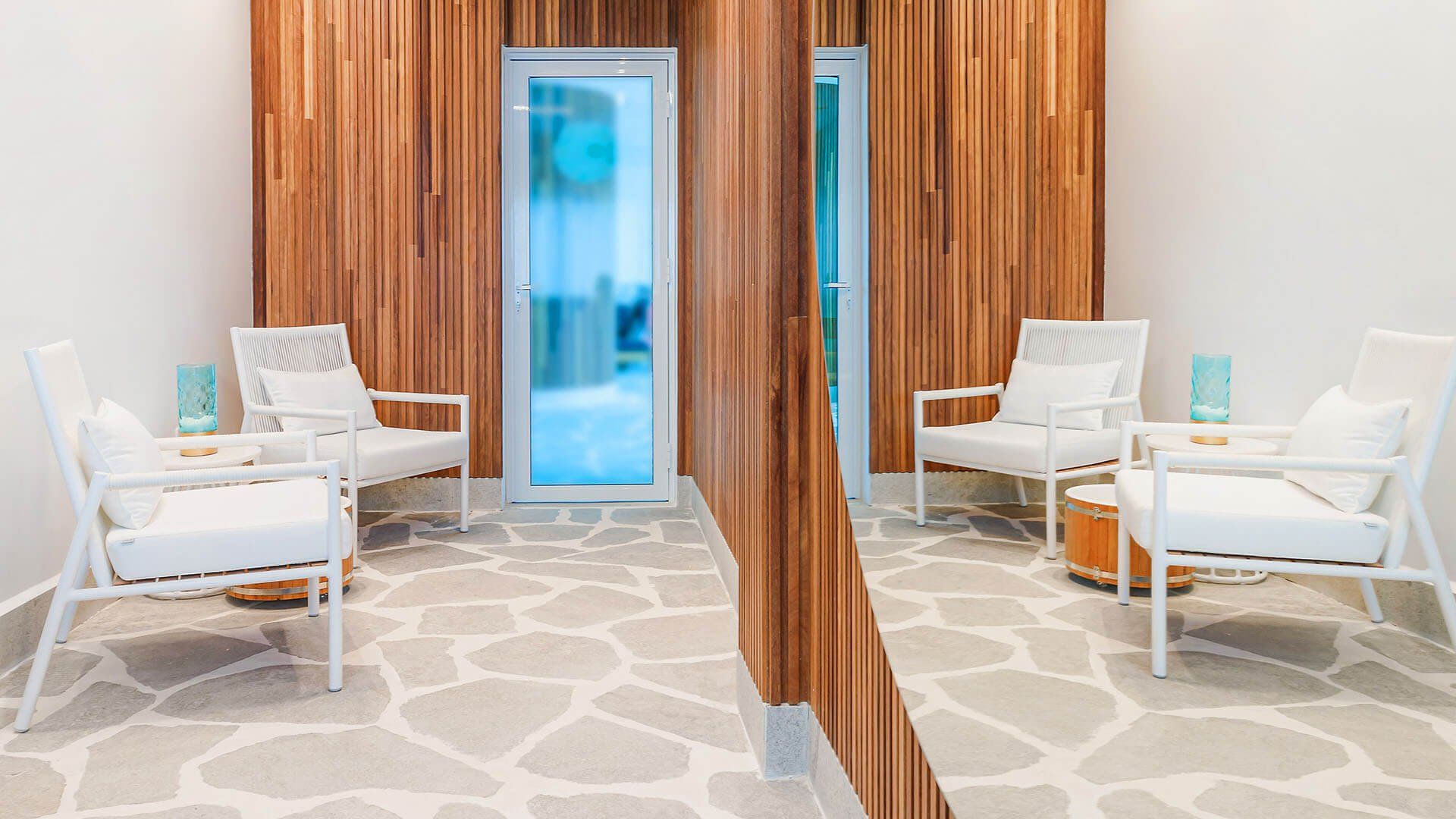 Há duas cadeiras e um espelho na sala.