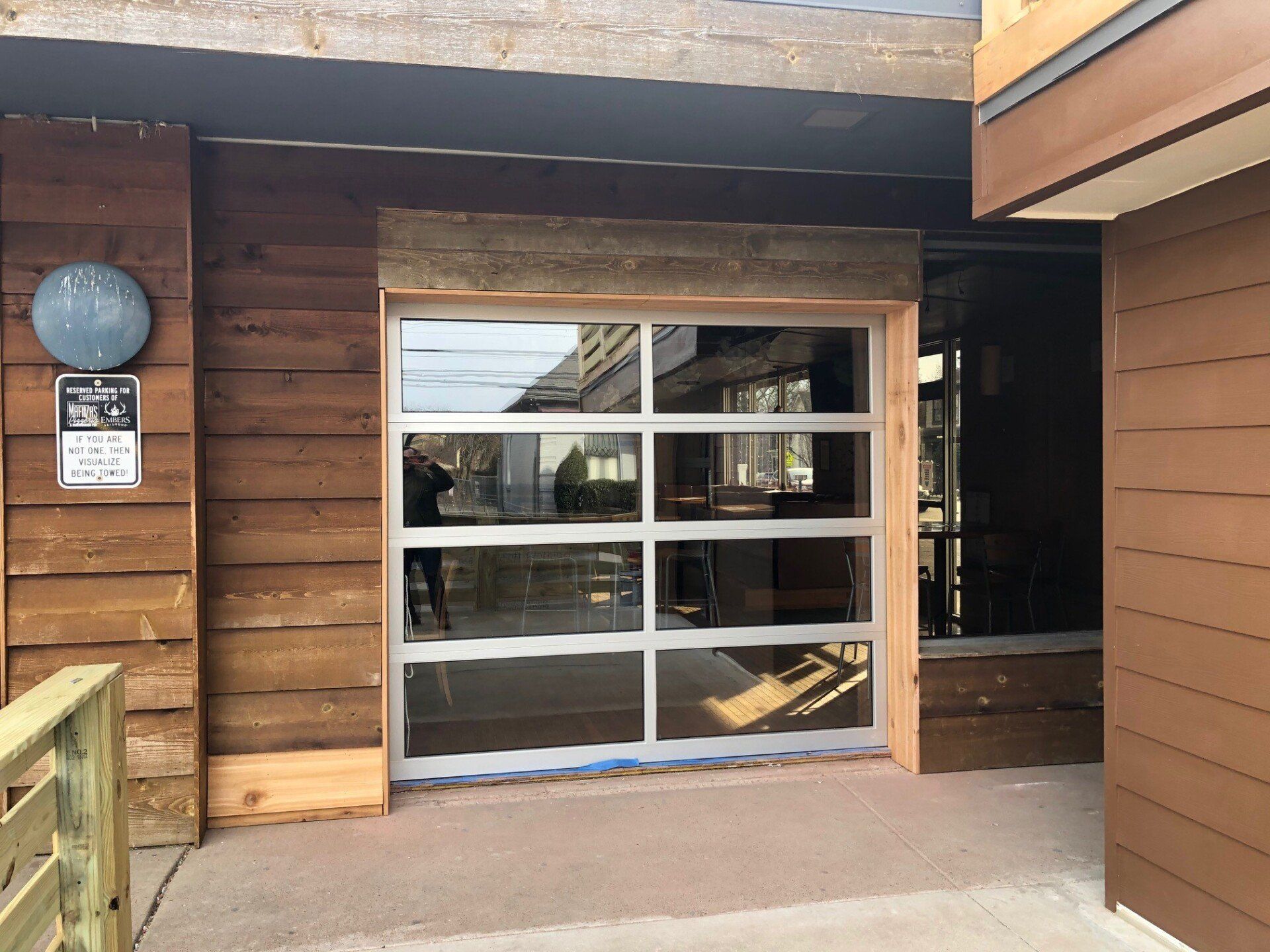 Glass-paned door on a building with weathered wood siding. A wooden beam tops the door.