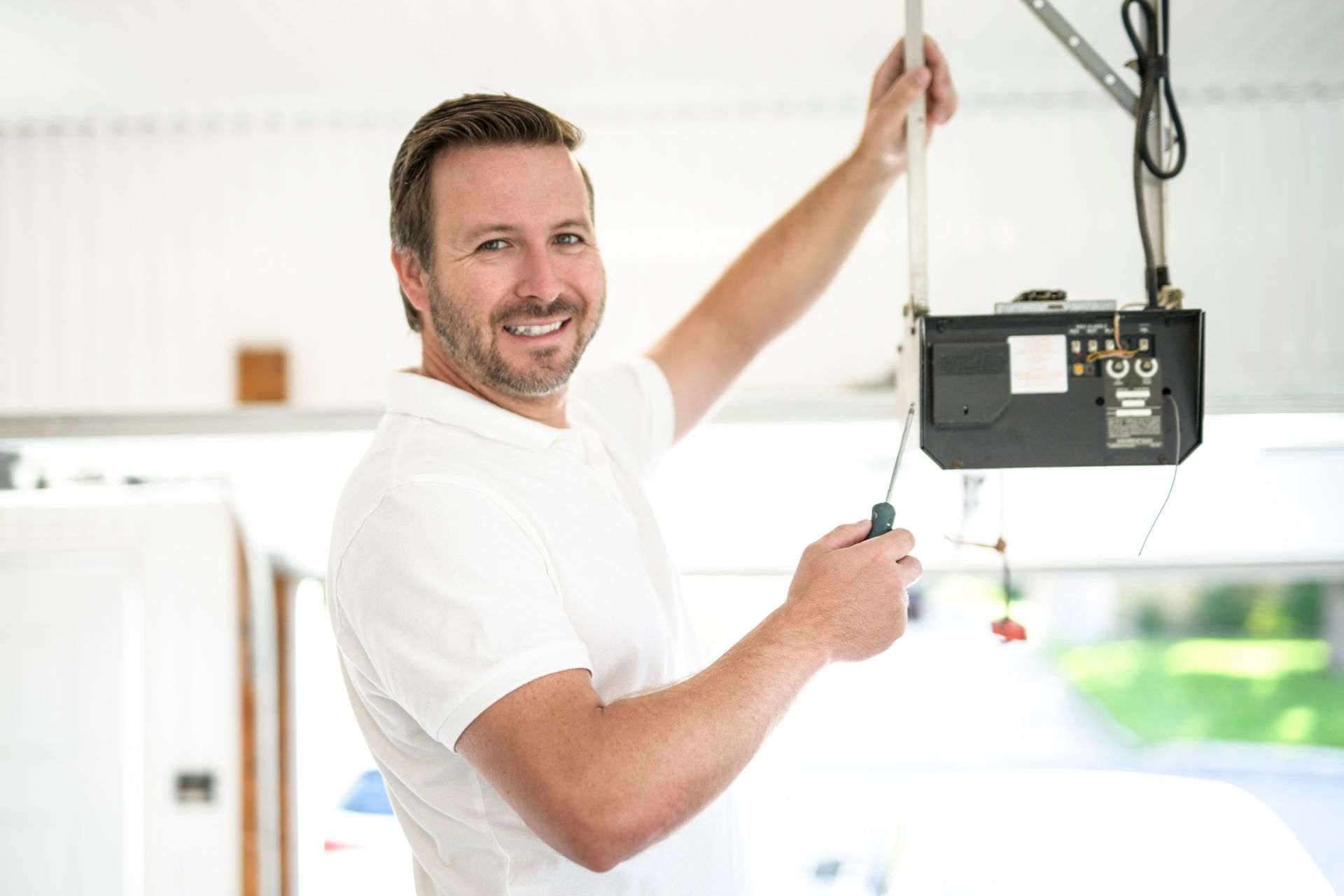 Technician inspecting garage door for repair and safety. Technician inspecting garage door for repair and safety.