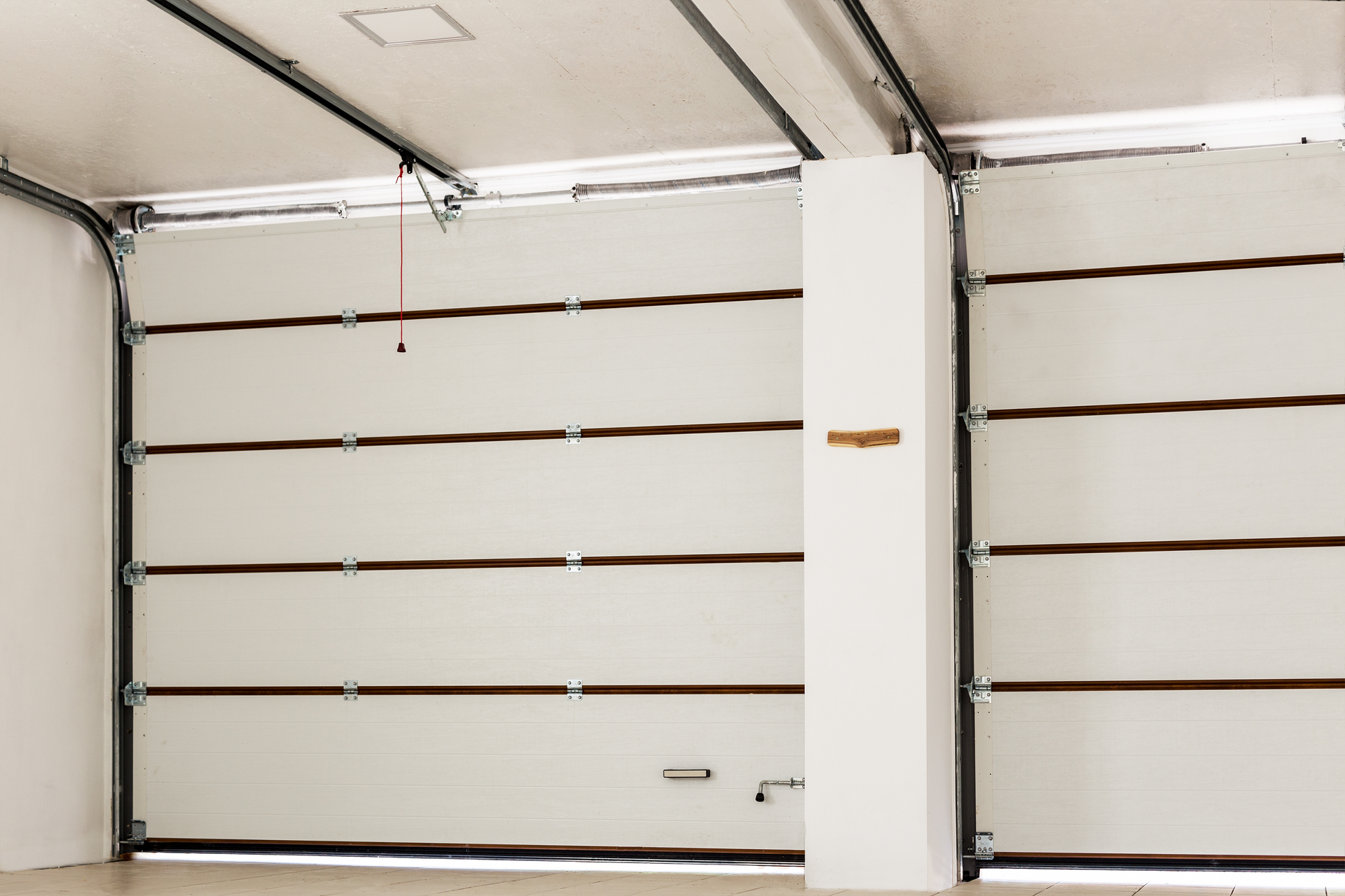 Empty double-story garage showcasing garage door opener repair with automatic doors inside.
