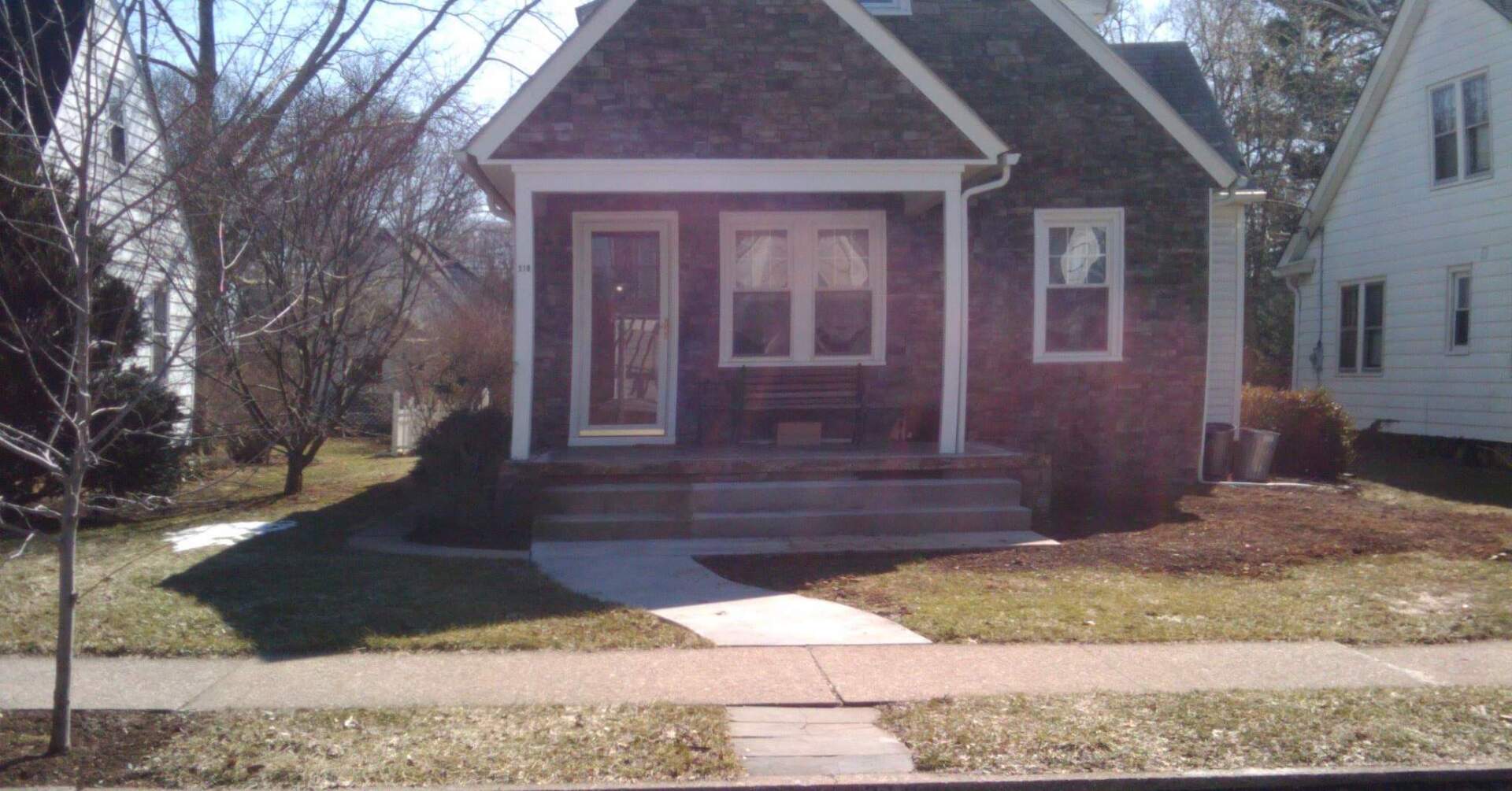A small brick house with a porch and stairs