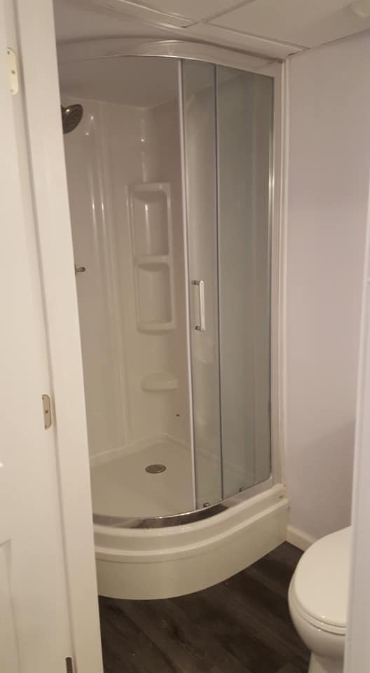 A bathroom with a shower stall and a toilet.