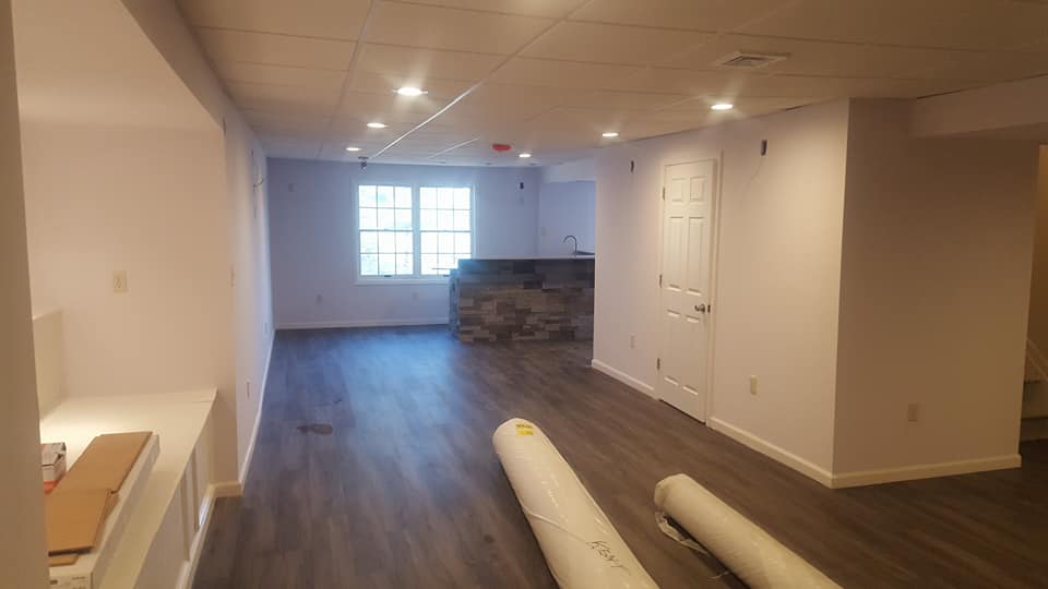 A large empty room with hardwood floors and white walls.
