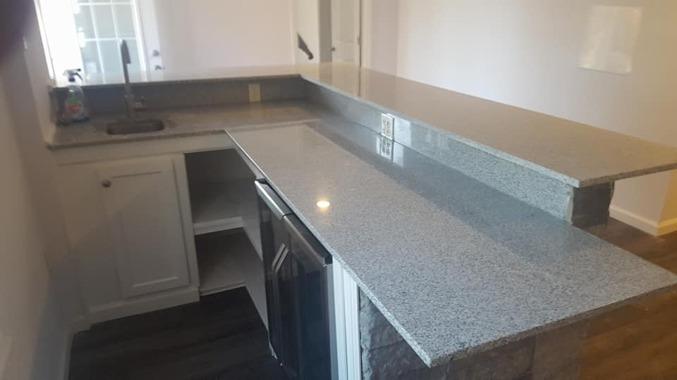 A kitchen with granite counter tops and white cabinets.