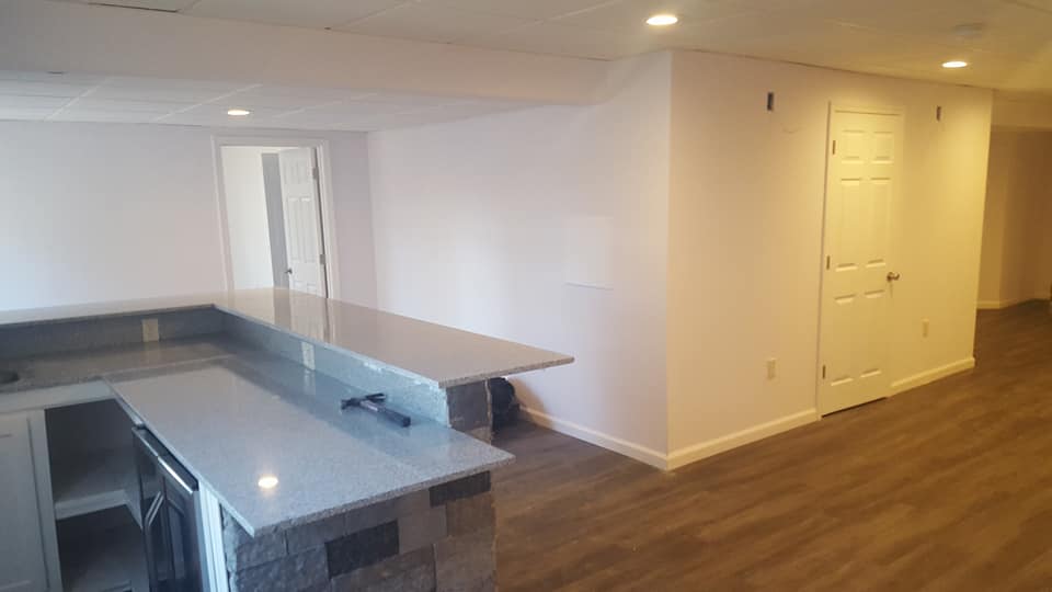 A kitchen with a large island , stainless steel appliances , and hardwood floors.