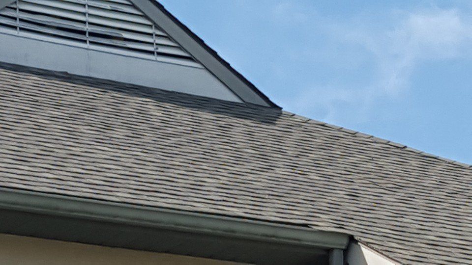 A close up of a roof with a blue sky in the background.
