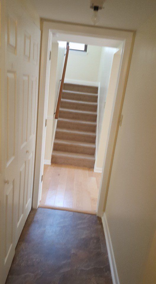 A hallway with stairs leading up to the second floor of a house.