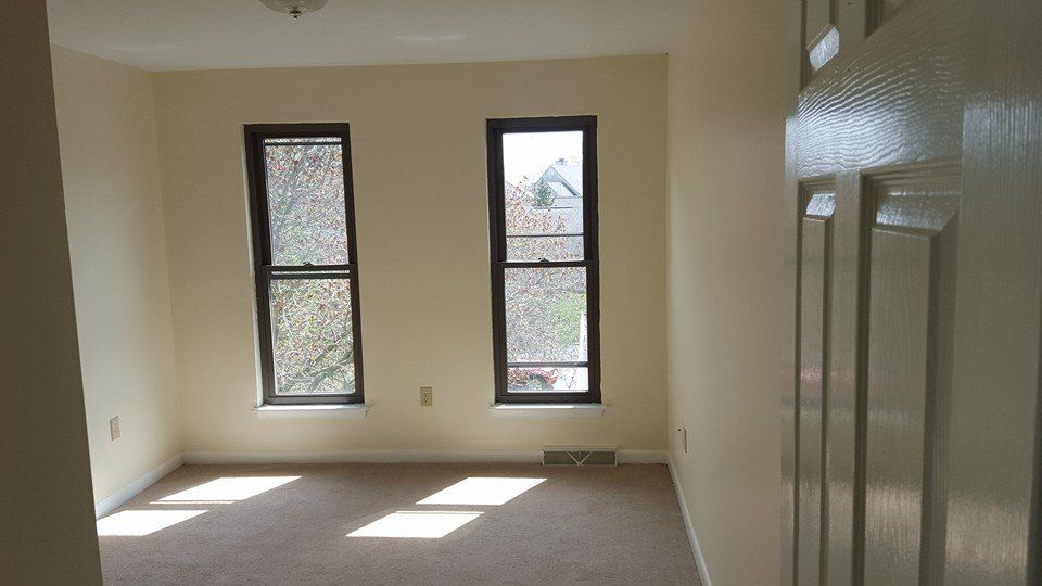 An empty room with two windows and a door