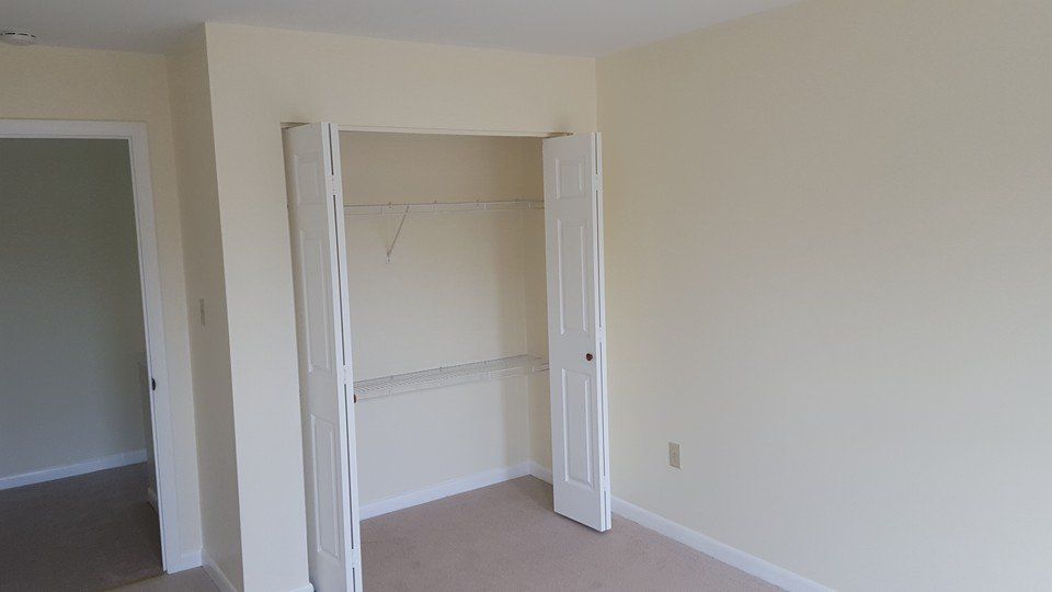 An empty bedroom with a closet and a door.
