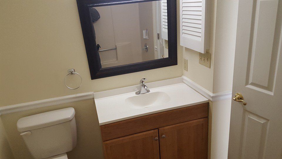 A bathroom with a sink , toilet and mirror.