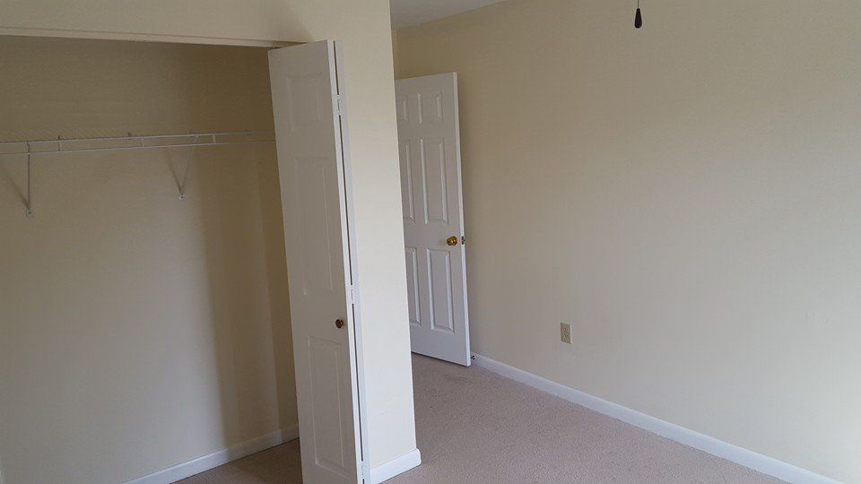 An empty bedroom with a closet and a door.