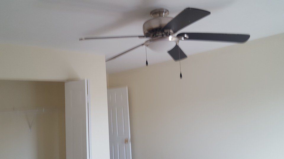 There is a ceiling fan in the corner of the room.