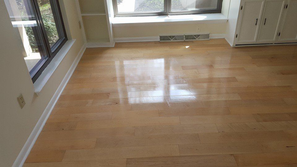 A living room with hardwood floors and a window.
