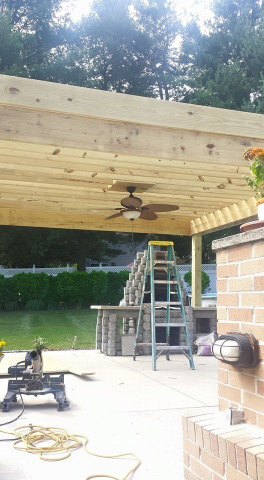 A ceiling fan is hanging from the ceiling of a wooden structure.