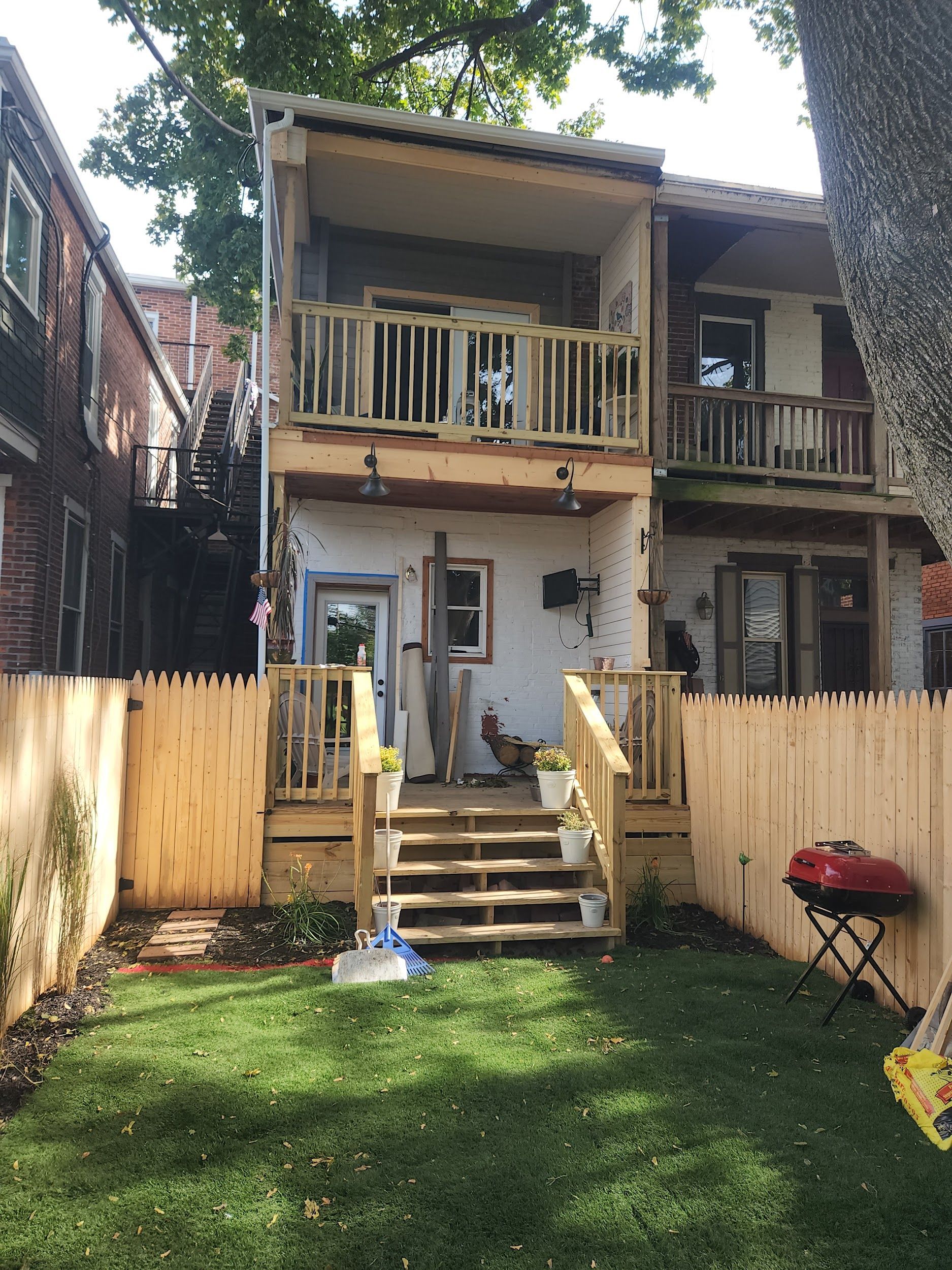The backyard of a house with a wooden fence and stairs