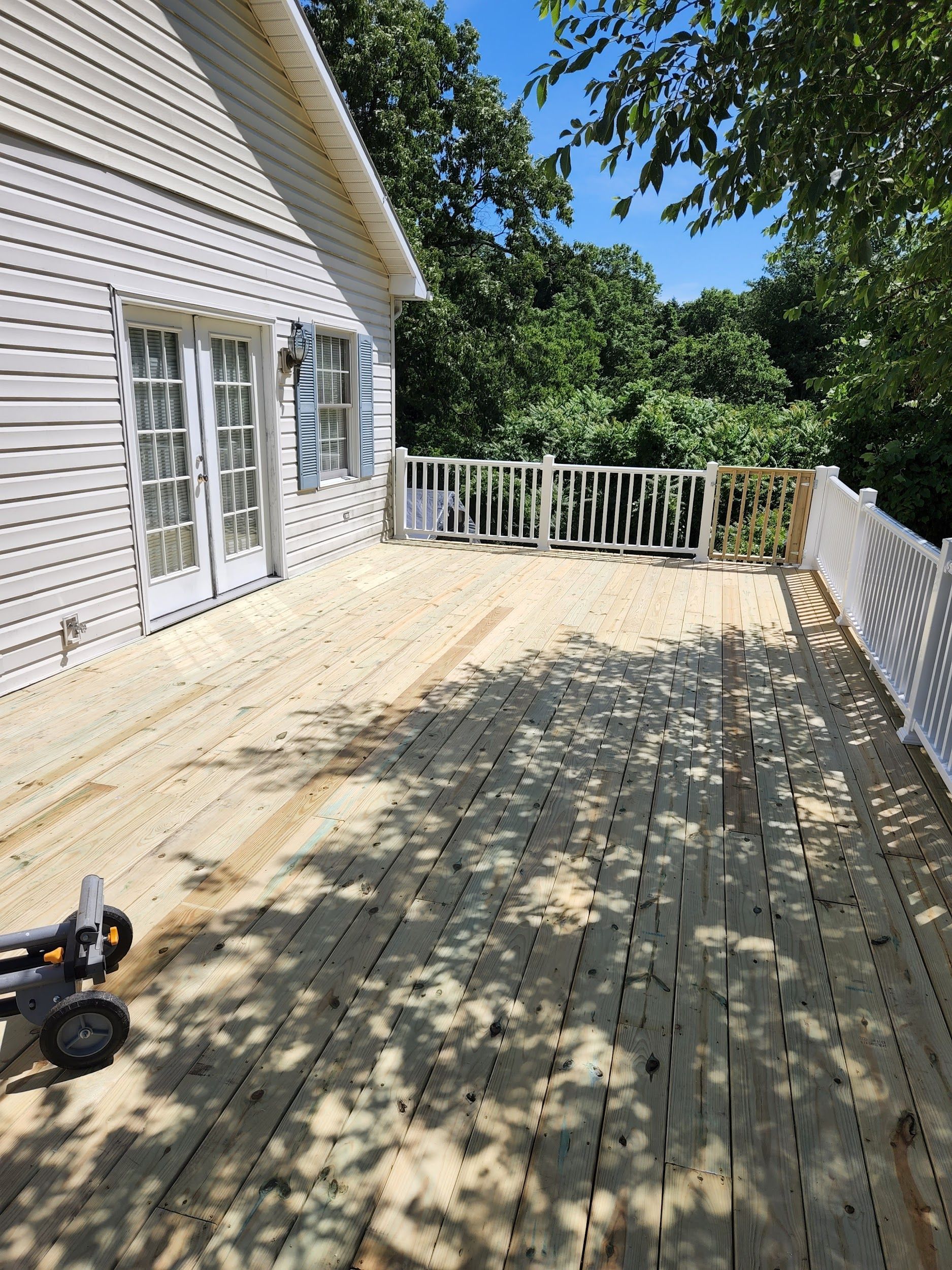 A large wooden deck is being built on the side of a house.