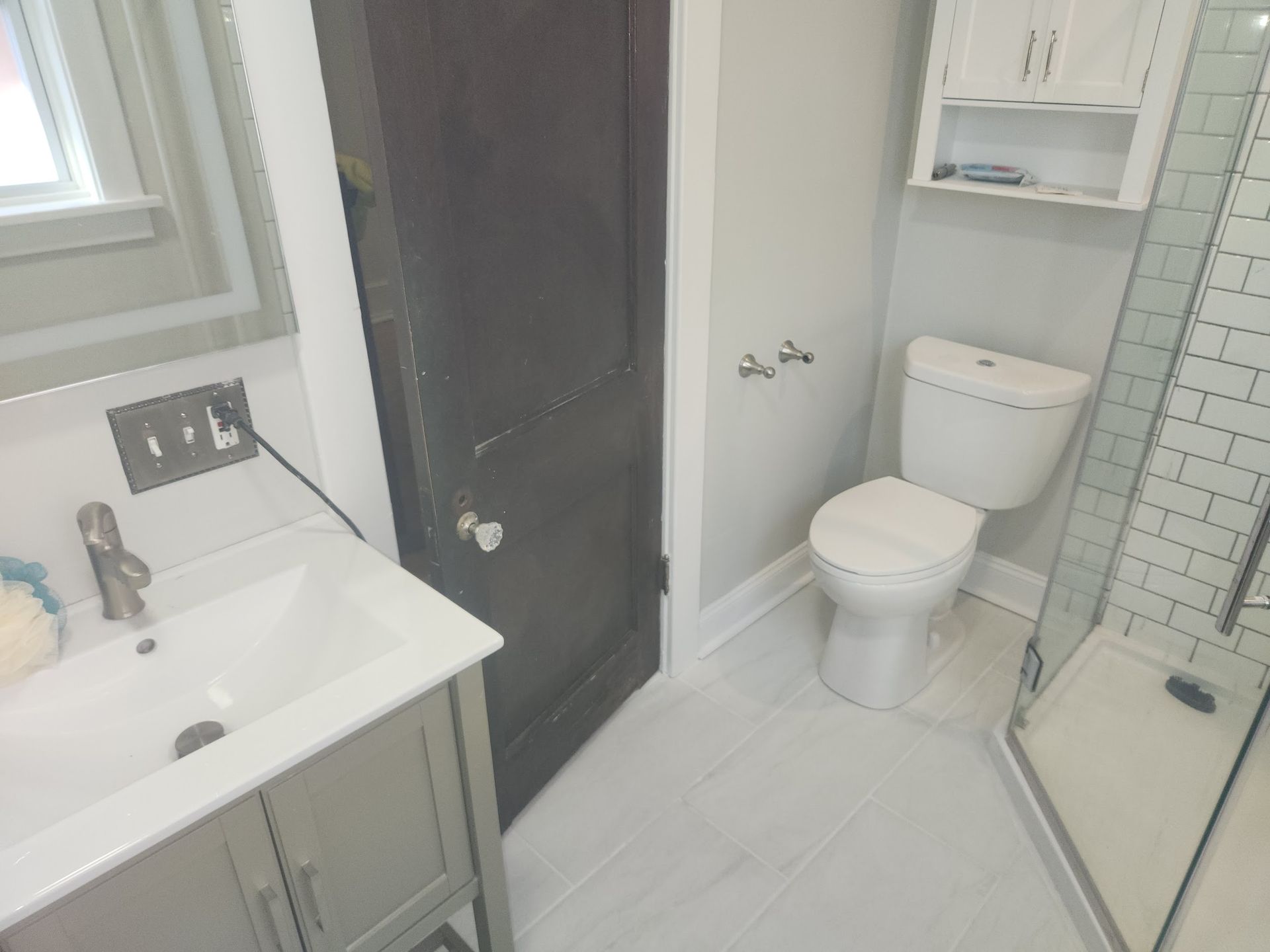 A bathroom with a toilet , sink and shower.