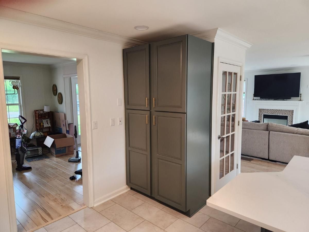 A kitchen with a gray cabinet and a french door.