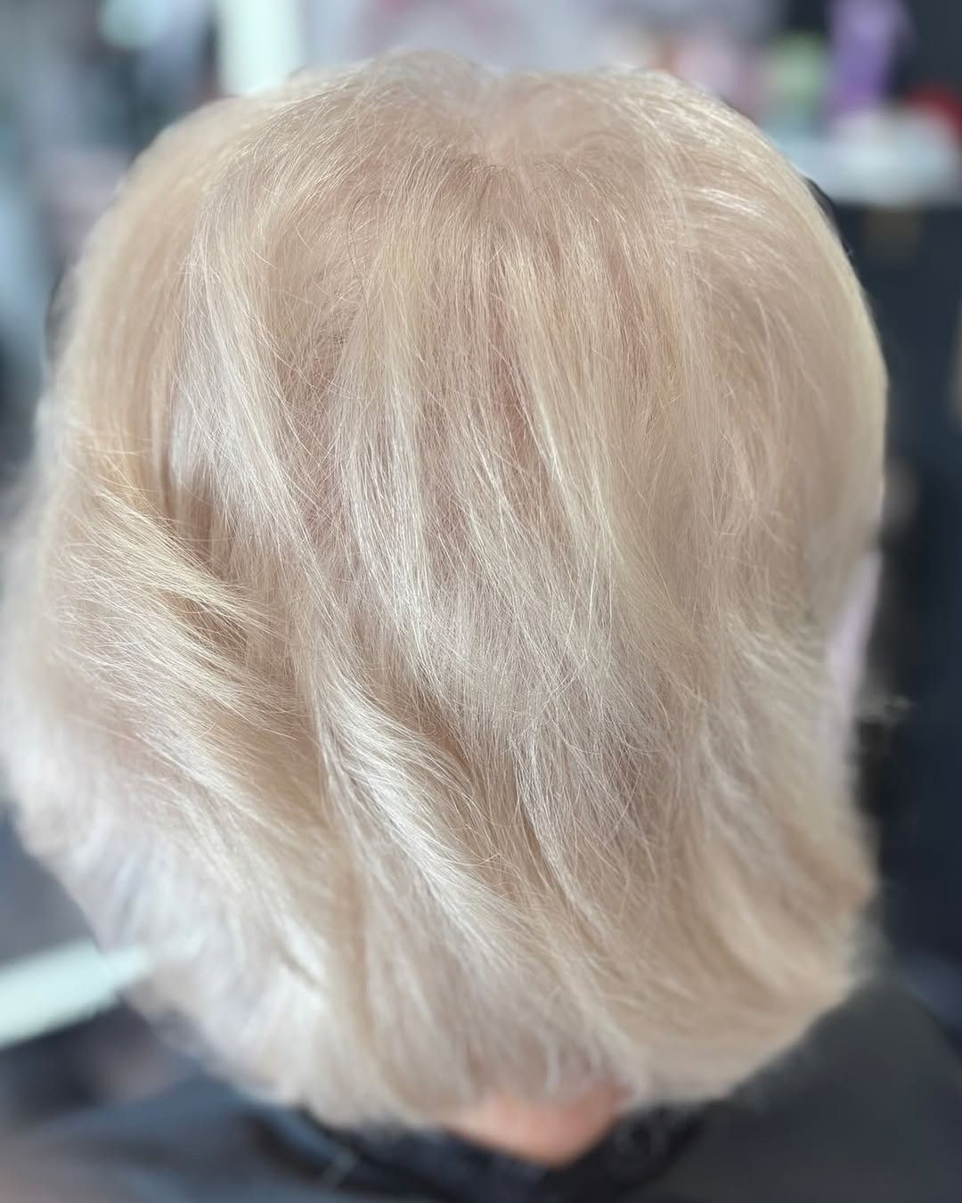 Back of a person's head with short, light blonde hair.