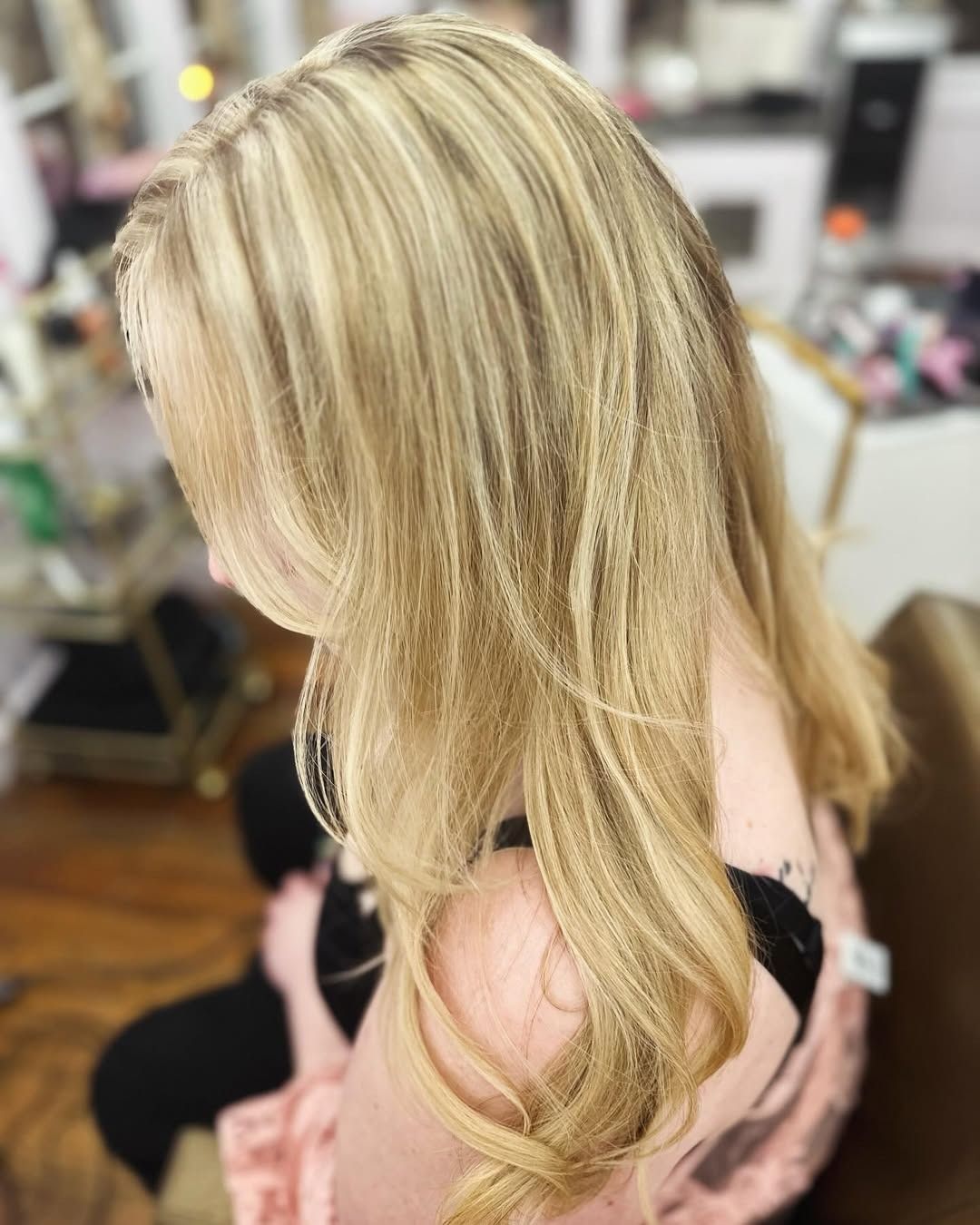 Blonde hair with highlights, styled with a side part.