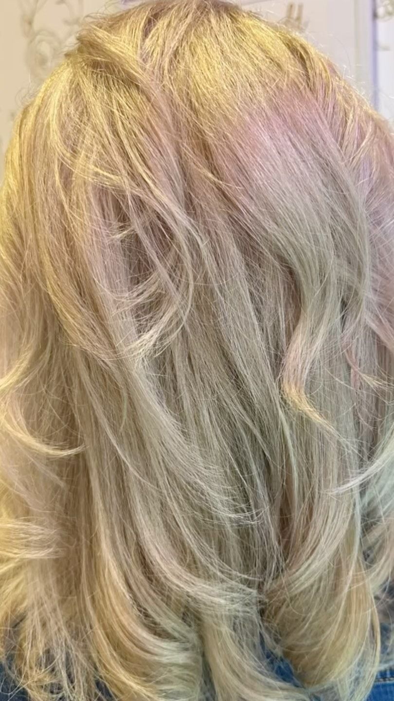 Blond, wavy hair; light and layered with a slightly pink hue.