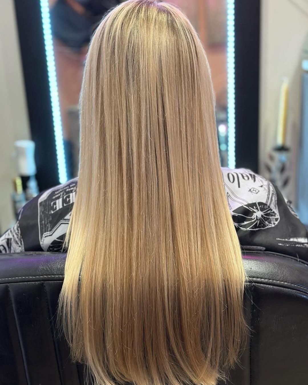 Long, straight blonde hair; back view in a salon chair.