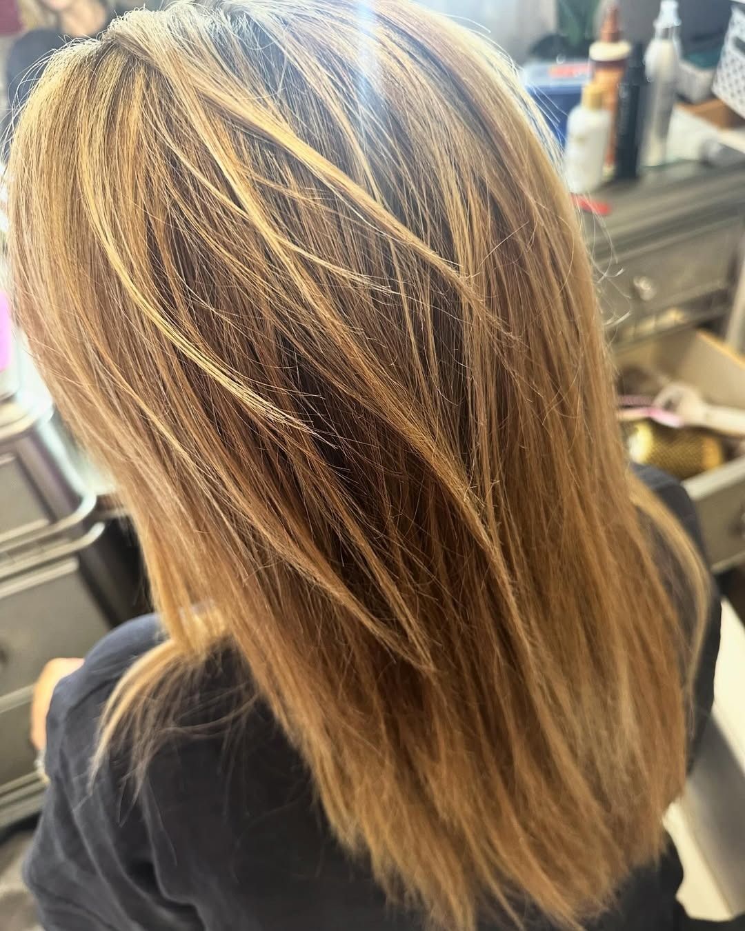 Blonde and brown layered hair; highlights catch the light.