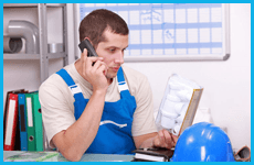 Man in blue overalls on the phone