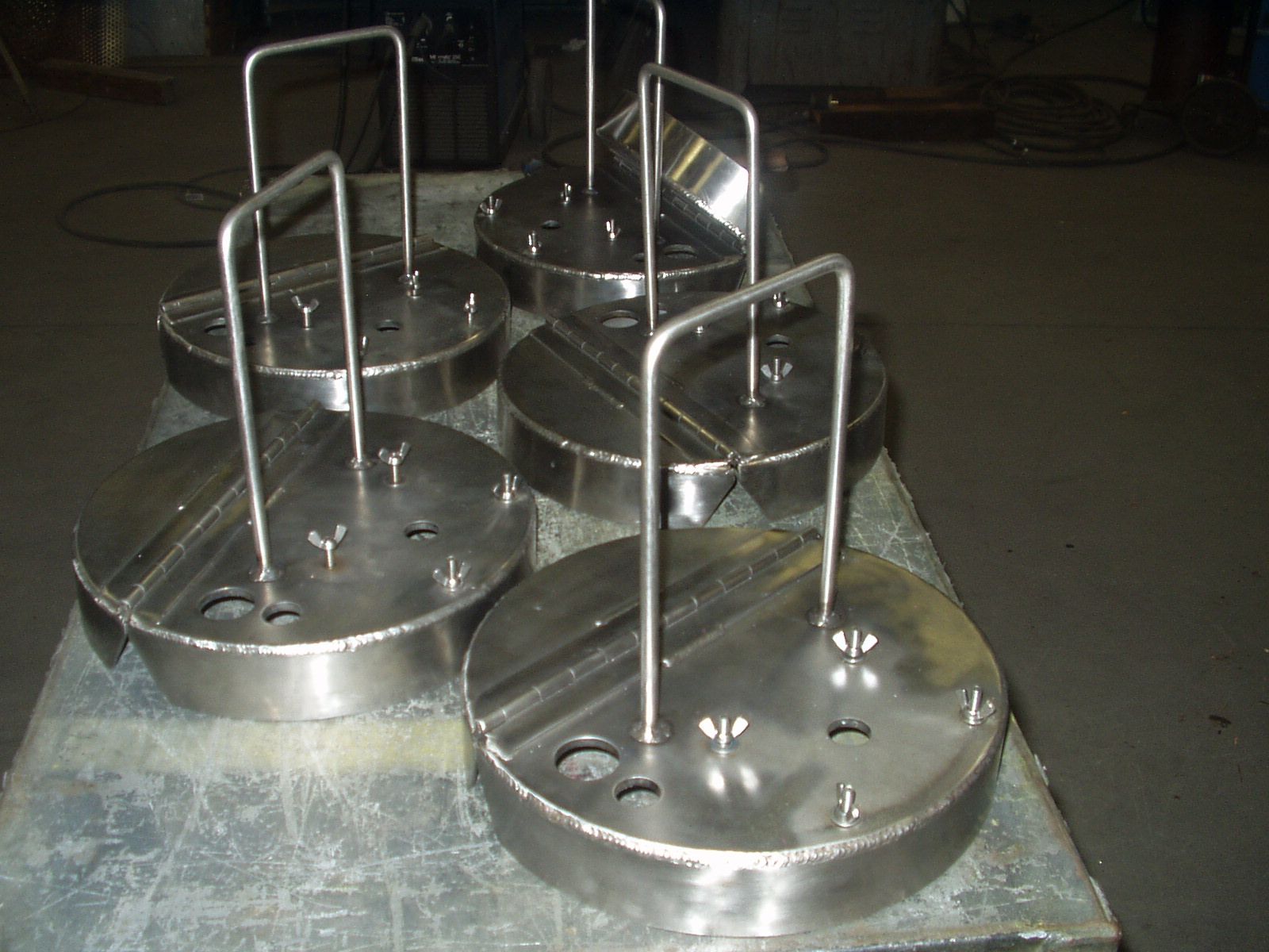 A man wearing a welding mask is welding a piece of metal.