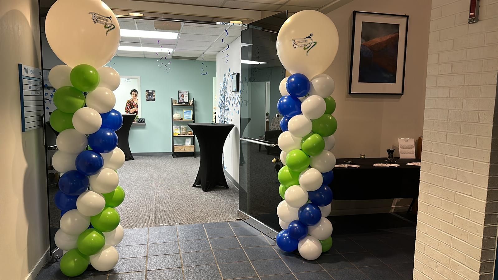 A hallway with blue , white and green balloons
