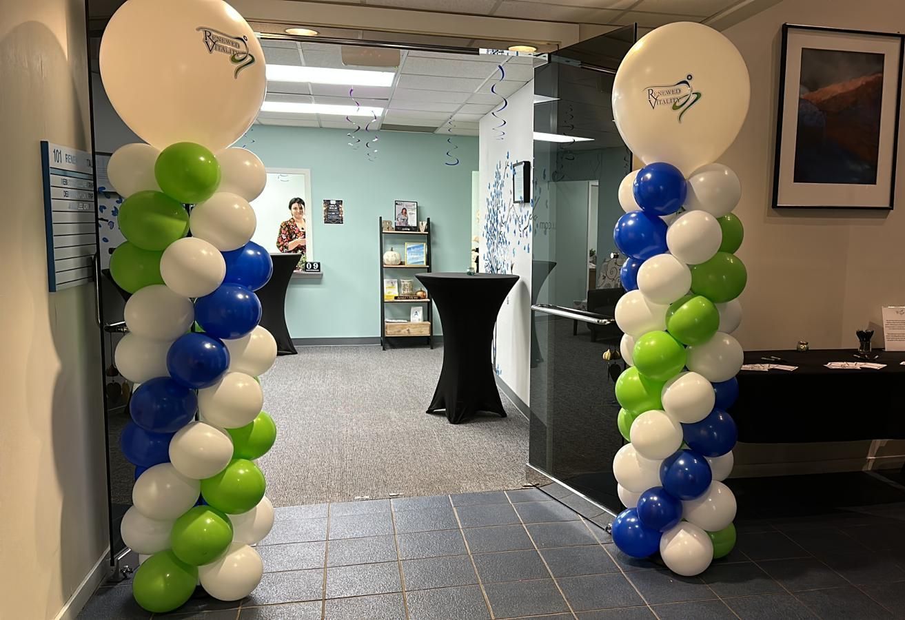 A balloon tower is sitting on top of a staircase in a room.