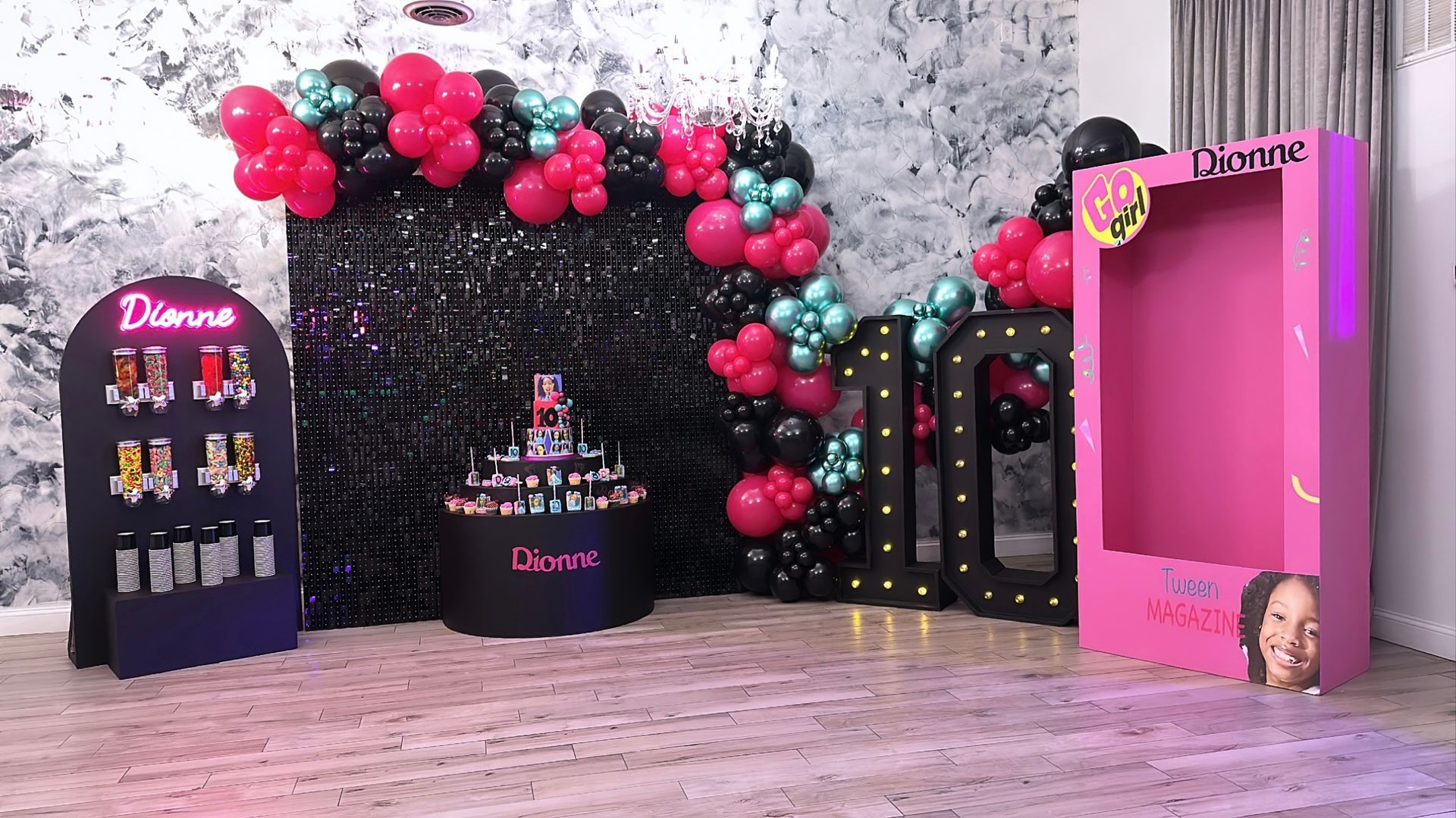 A room filled with balloons and a pink box.