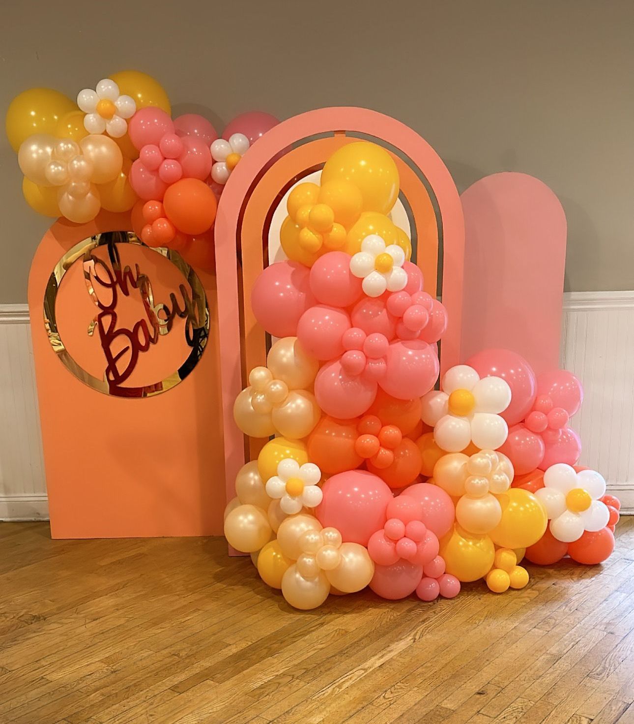 A bunch of balloons are sitting on a wooden floor.