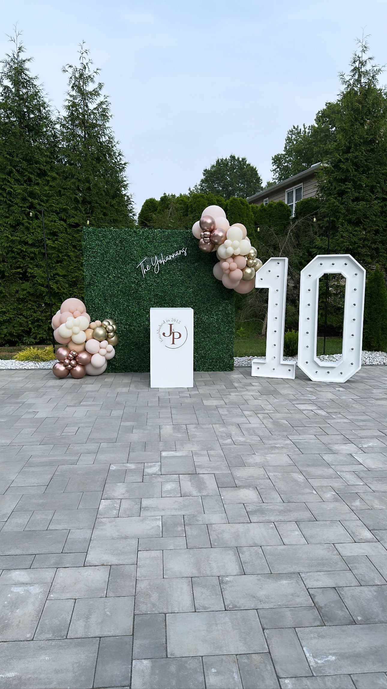 A brick driveway with balloons and a sign that says `` 10 ''.