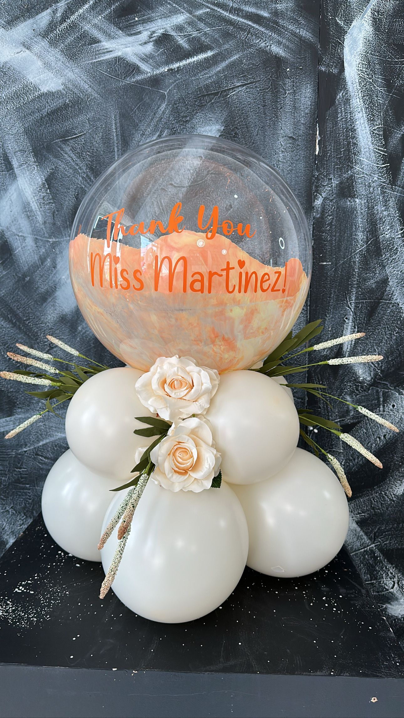 A bunch of white balloons are sitting on top of each other on a table.