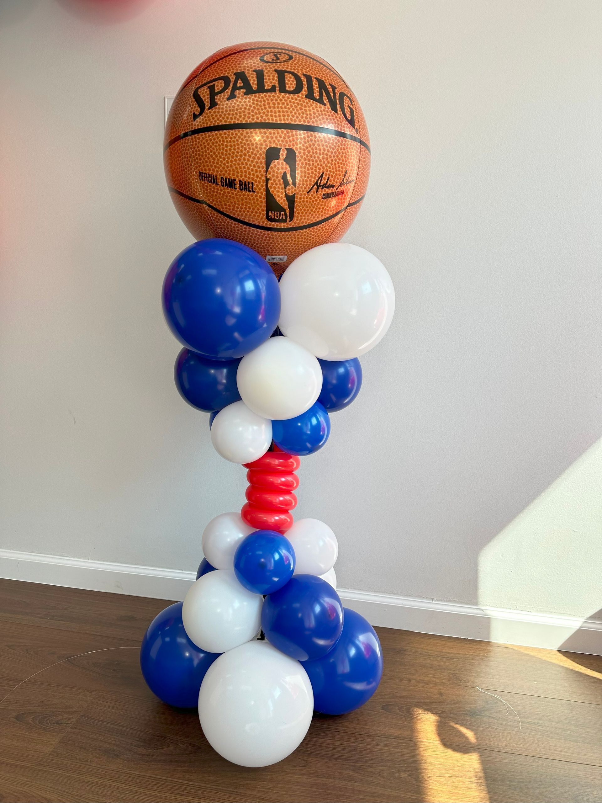 A balloon tower with a basketball on top of it