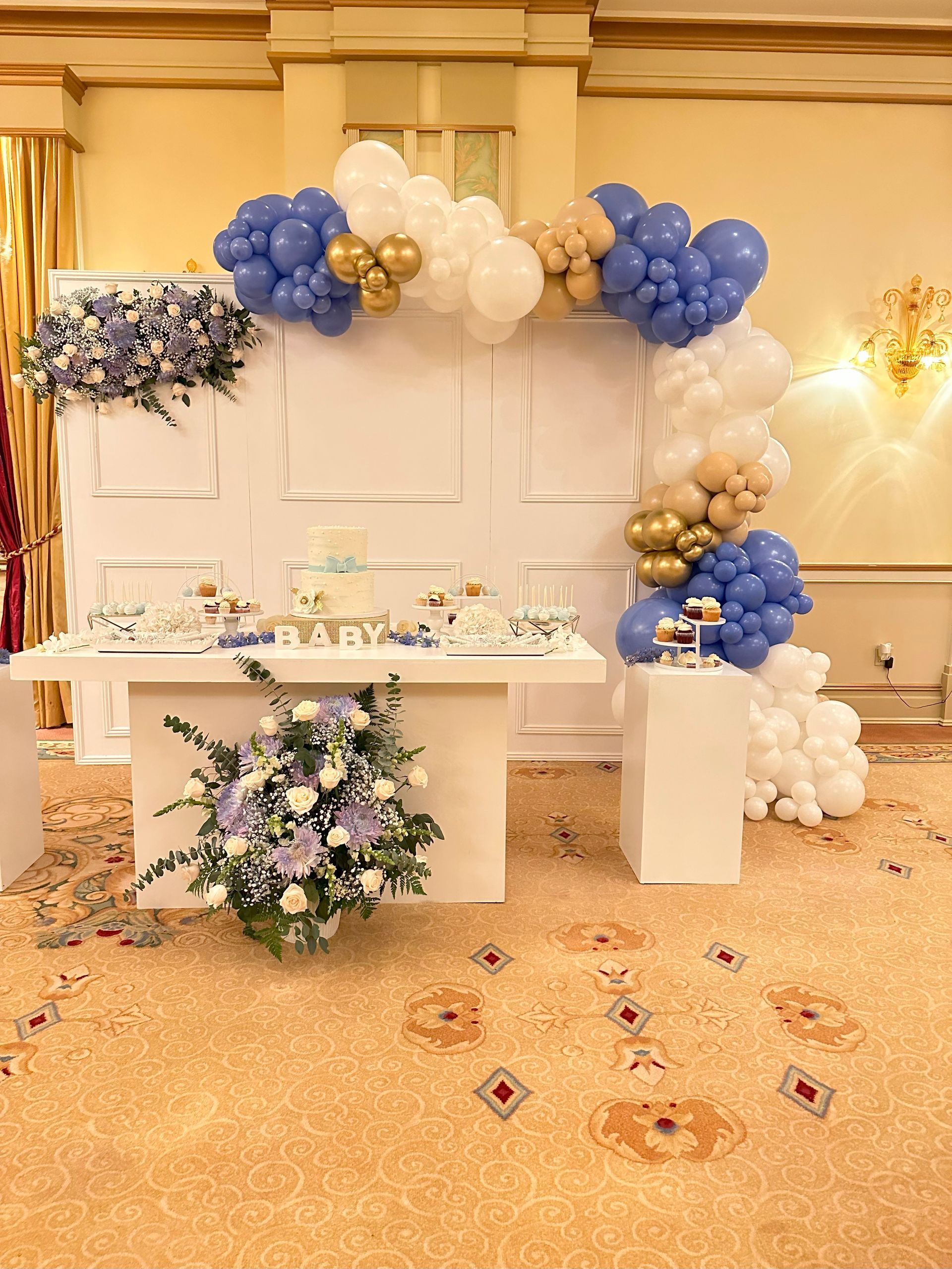 A table with balloons and flowers on it in a room.
