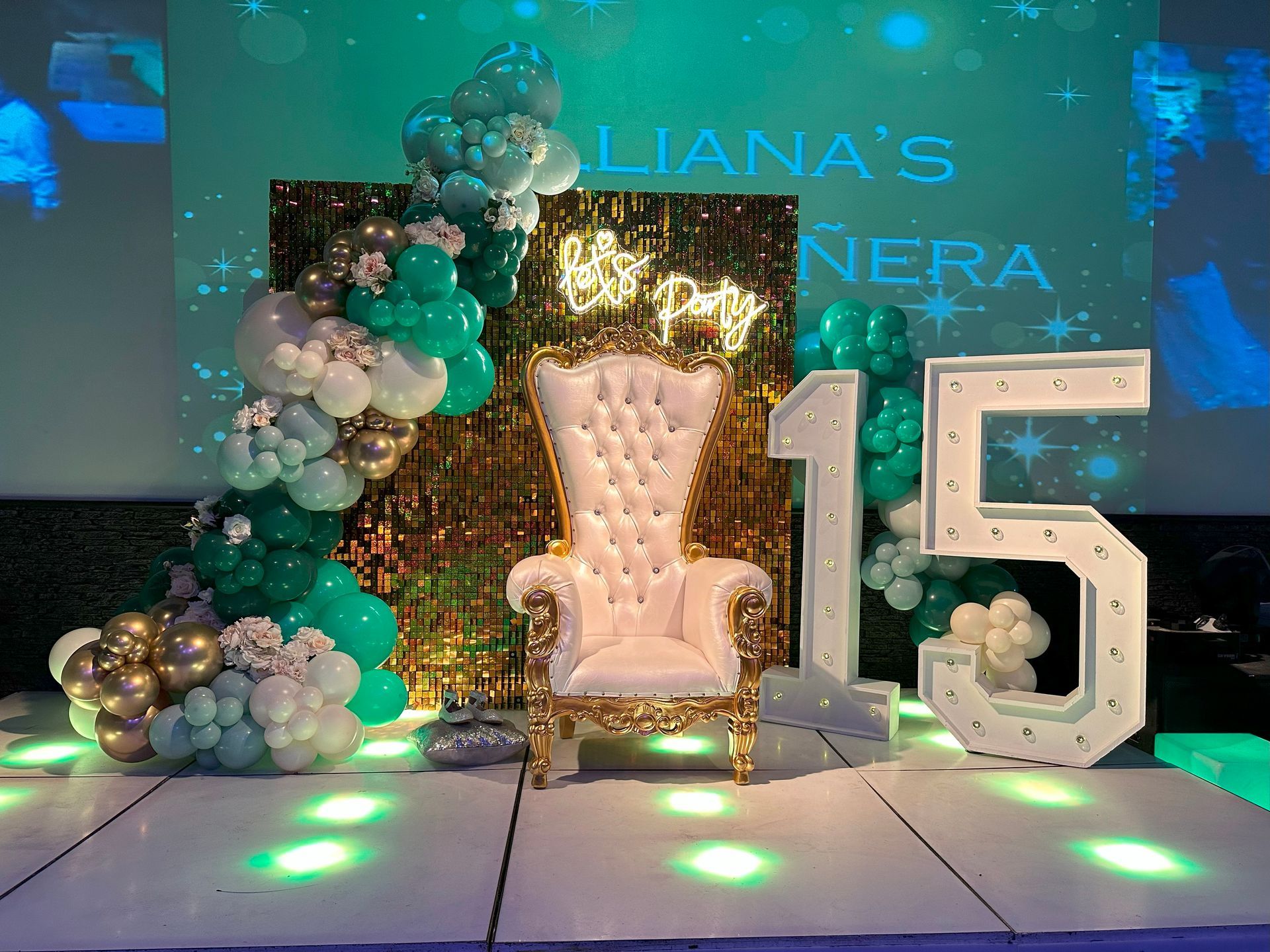A chair is sitting on a stage with balloons and a number 15.