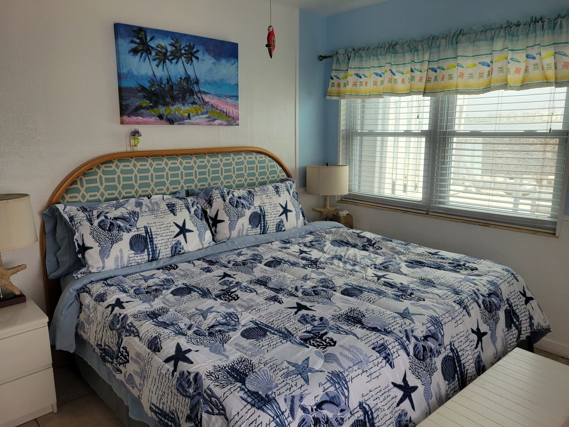 A bedroom with a king size bed and a painting on the wall above it.