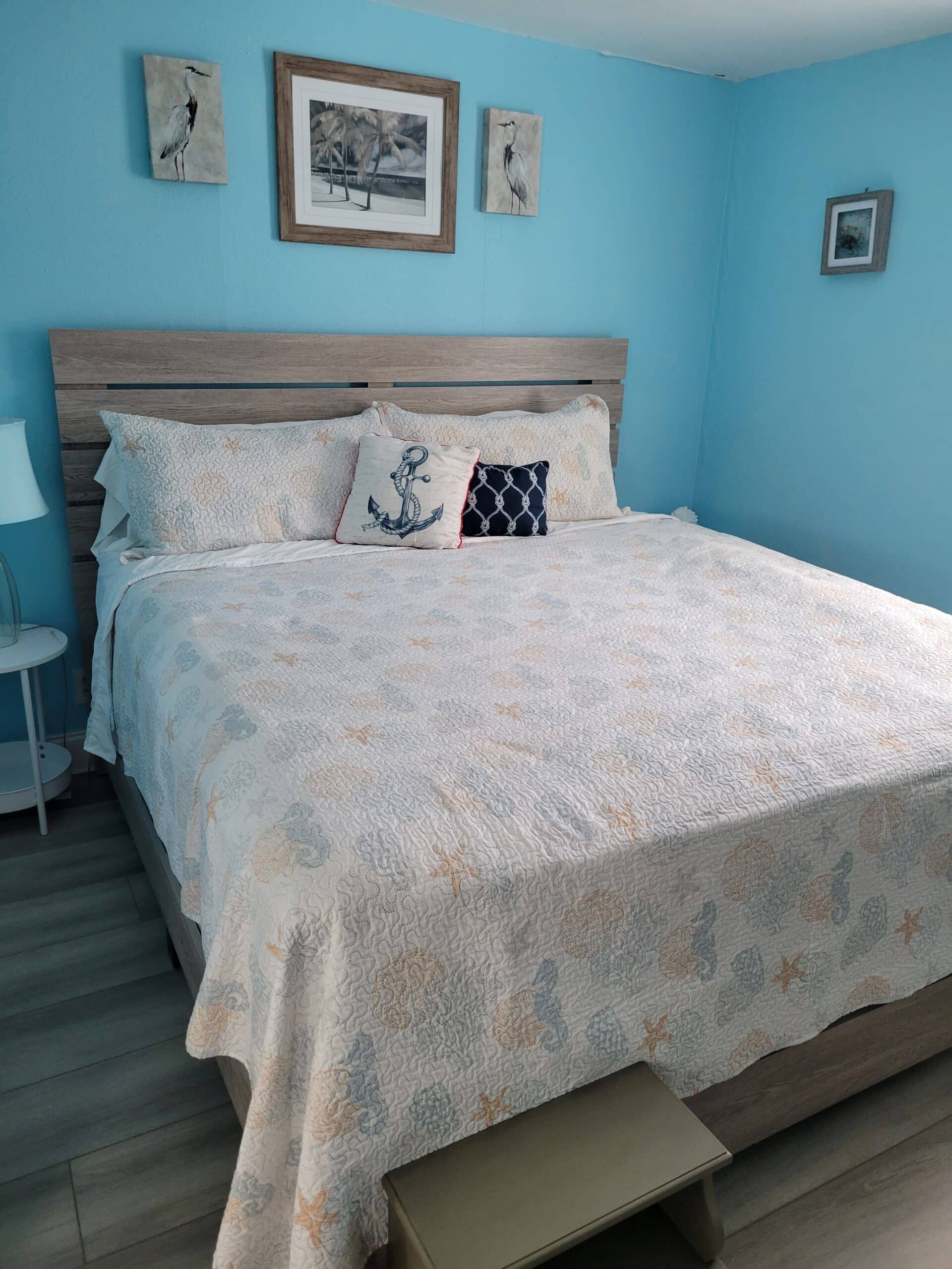 A bedroom with a king size bed and blue walls.