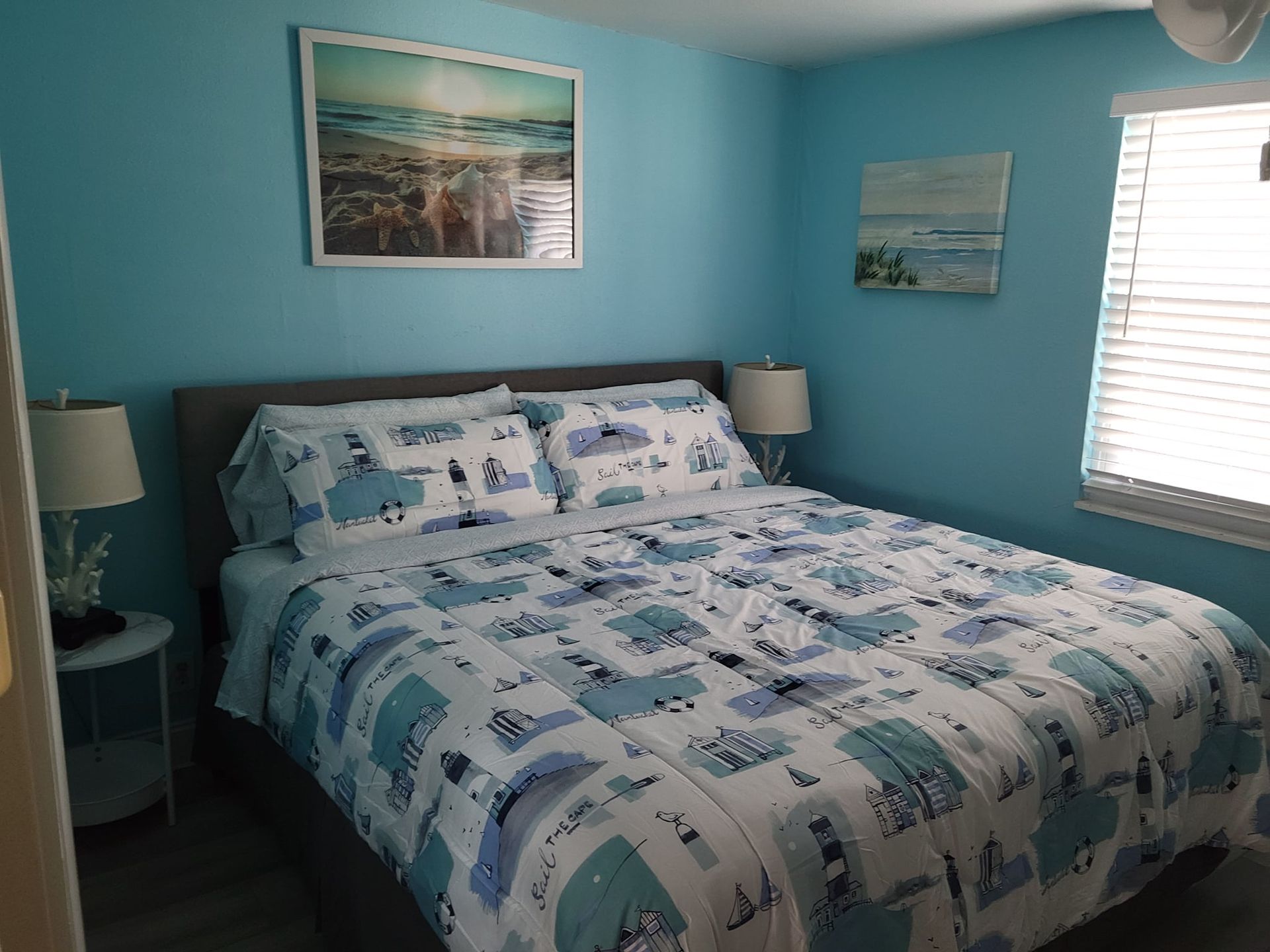 A bedroom with a king size bed and a picture on the wall above it.