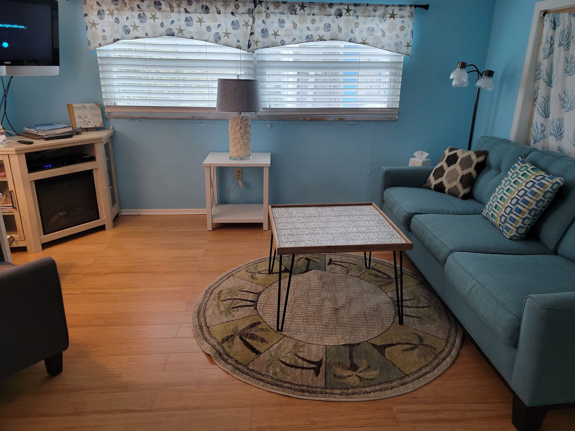 A living room with a couch , table , rug and television.