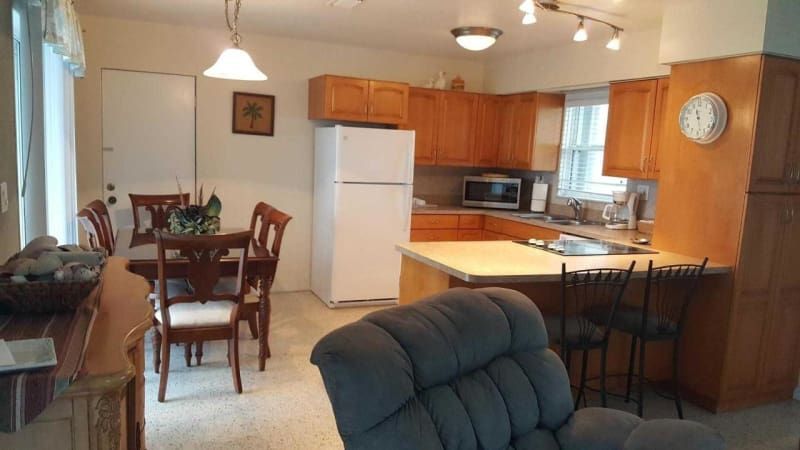 A kitchen with a refrigerator and a clock on the wall