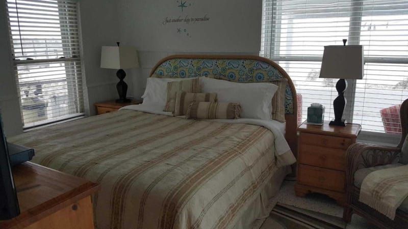 A bedroom with a king size bed , two nightstands , a chair and a window.