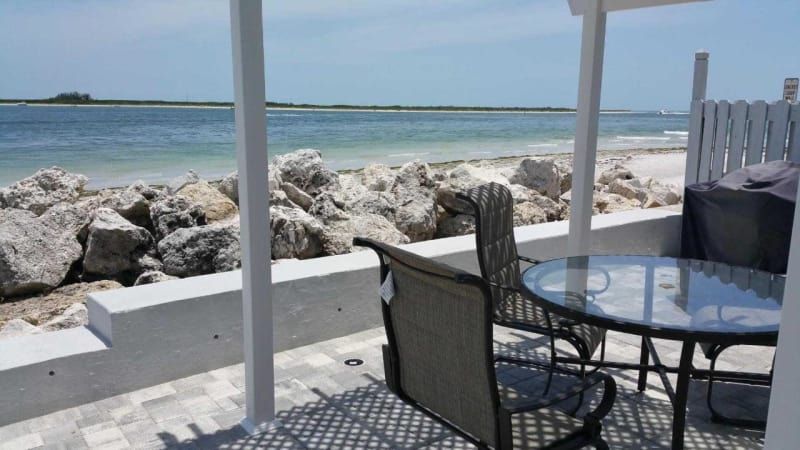 A patio with a table and chairs overlooking the ocean