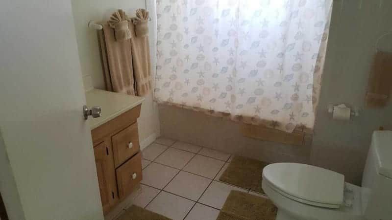A bathroom with a toilet , sink and shower curtain.