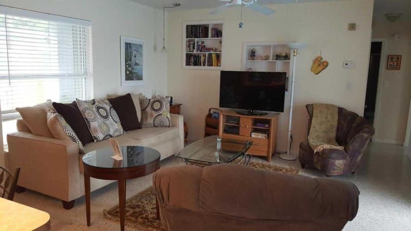 A living room with a couch , chair , table and television.