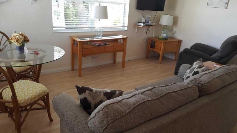 A living room with a couch , chairs , table and television.